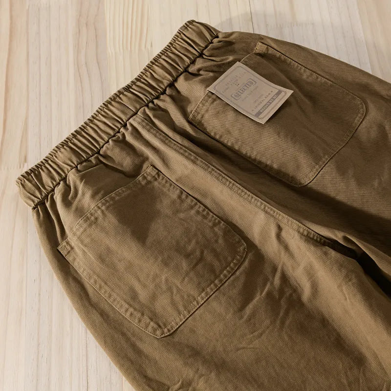 Men's army green cotton overalls with drawstring waist and ankle-band legs on a plain background.