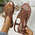Black Roman style cross strap buckle beach slippers with open toe and leather lining.