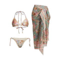 Women's creamy-white floral bikini swimsuit set with matching skirt on beach