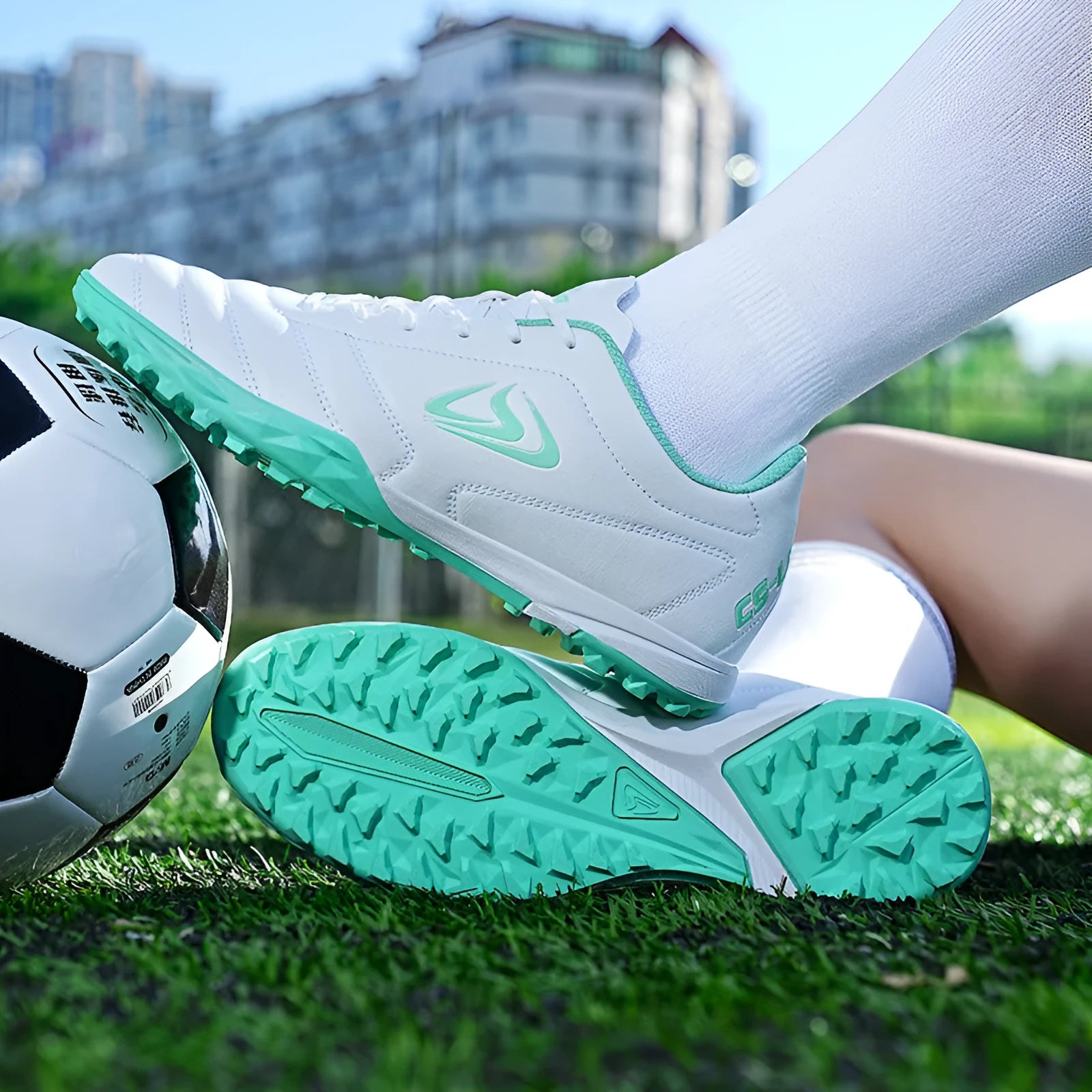 Low-top outdoor soccer football boots in a broken nail colour design with a synthetic leather upper and rubber sole.