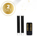 Set of four black LED taper candles with realistic 3D flame effect on a table.