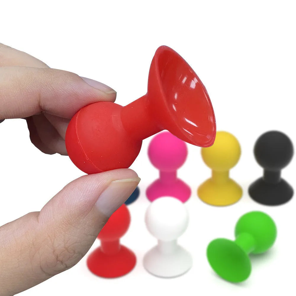Creative silicone octopus ball mobile phone holder in blue on a desk with a smartphone inserted