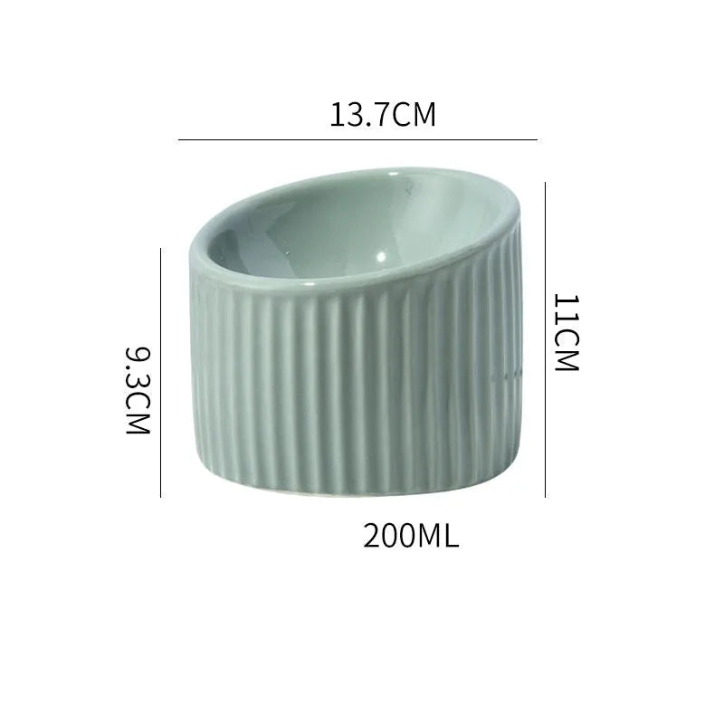 Dark green ceramic raised cat bowl with tilted design on a wooden surface.