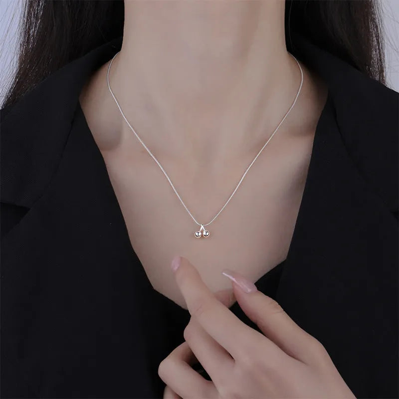 Silver cherry fruit pendant necklace on an adjustable snake bone chain for women.