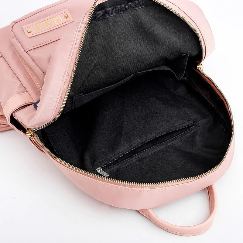Black nylon casual backpack with external pockets, shown with adjustable straps and a soft handle.