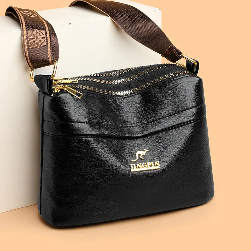 Brown cross body bag with multiple compartments and horizontal suitcase shape