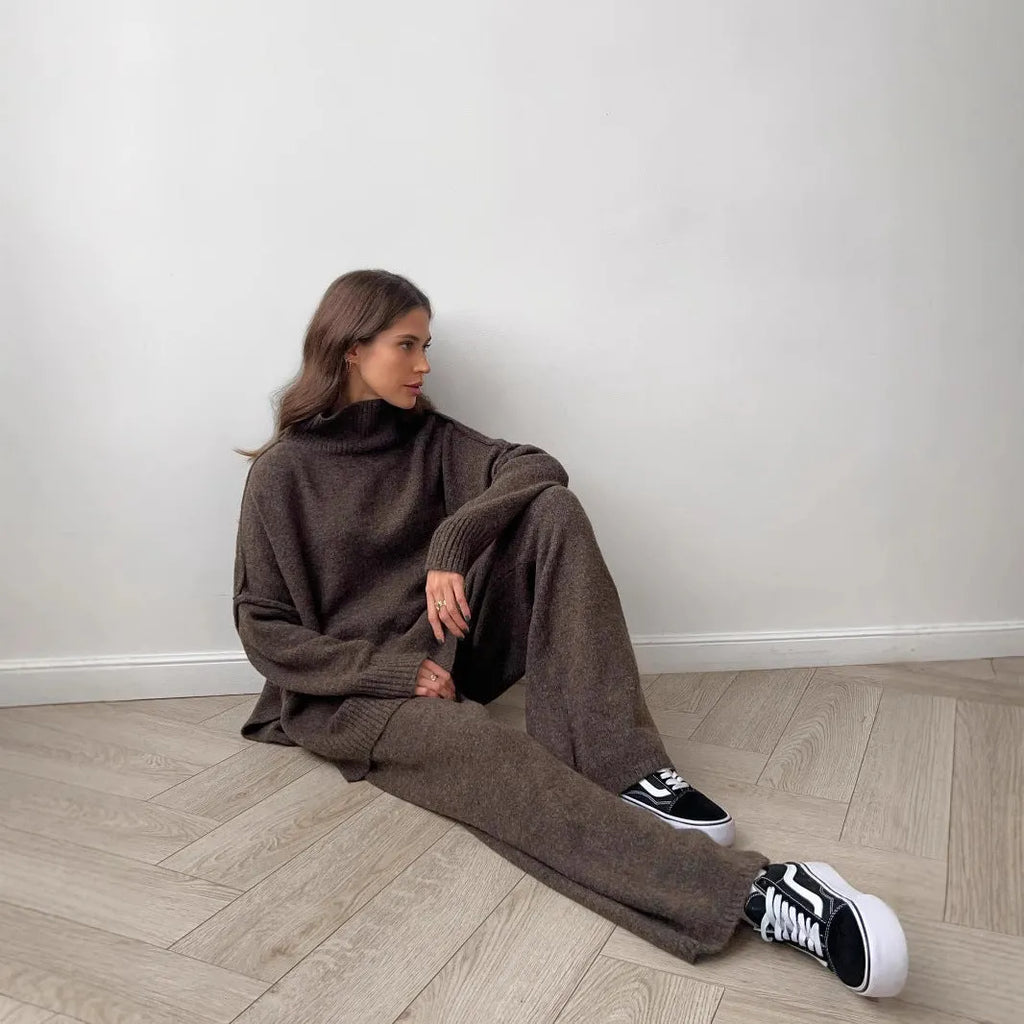 Women's dark grey knit co-ord suit with side-slit sweater top and matching trousers.