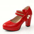 Red women's chunky heel platform shoes with a round toe and buckle fastening on a rubber sole.