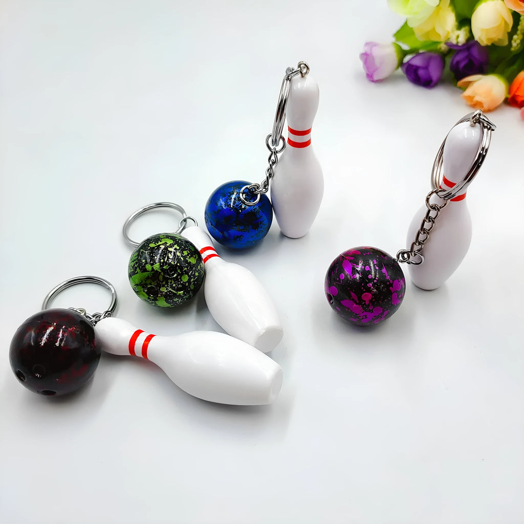 Mini simulation sports bowling ball keychain pendant in dark red, blue, purple, and green colours.