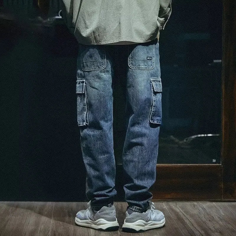 A pair of men's loose straight leg blue jeans on a plain background, showing the zip fly and classic denim style.