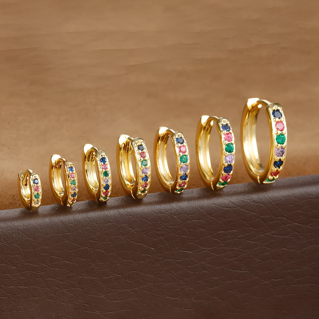 Circle zircon perforated stud earrings in gold, rose gold, and silver colour on a card.