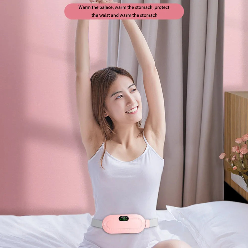 Pink and white menstrual heating belt with USB charger, controller, and long cable on a grey background.