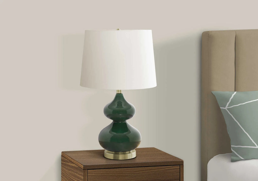 Blue crystal glass desk lamp with white fabric shade on a wooden desk.