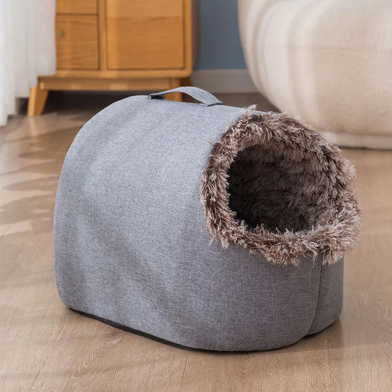 Grey fleece-lined enclosed cat sleeping bag bed for pets in a cage.