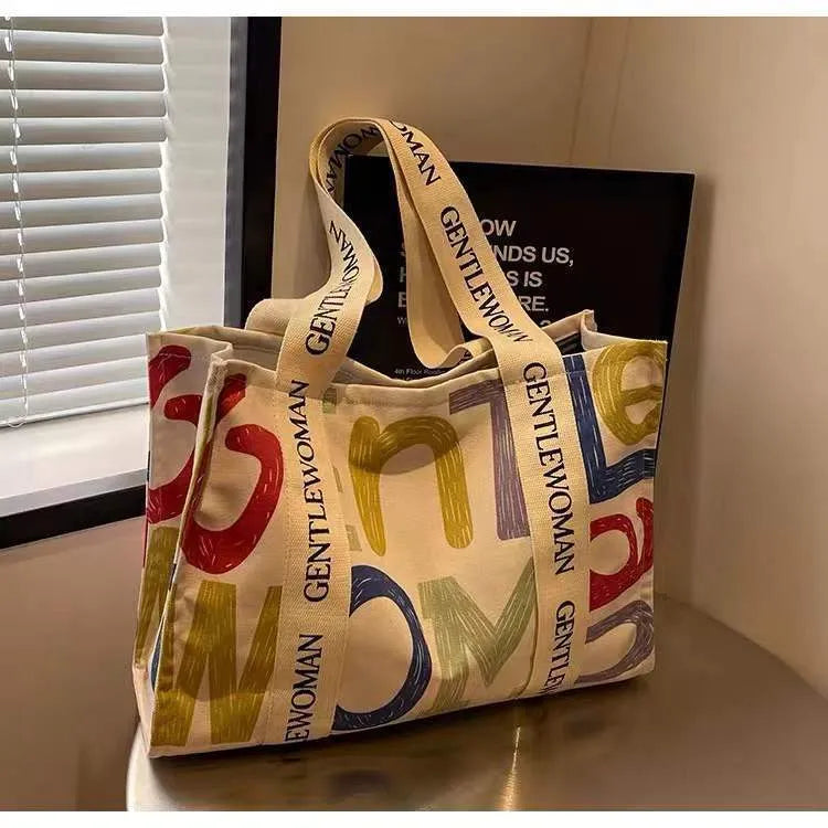 Large canvas women's tote bag with printed design, shown in available colour options.