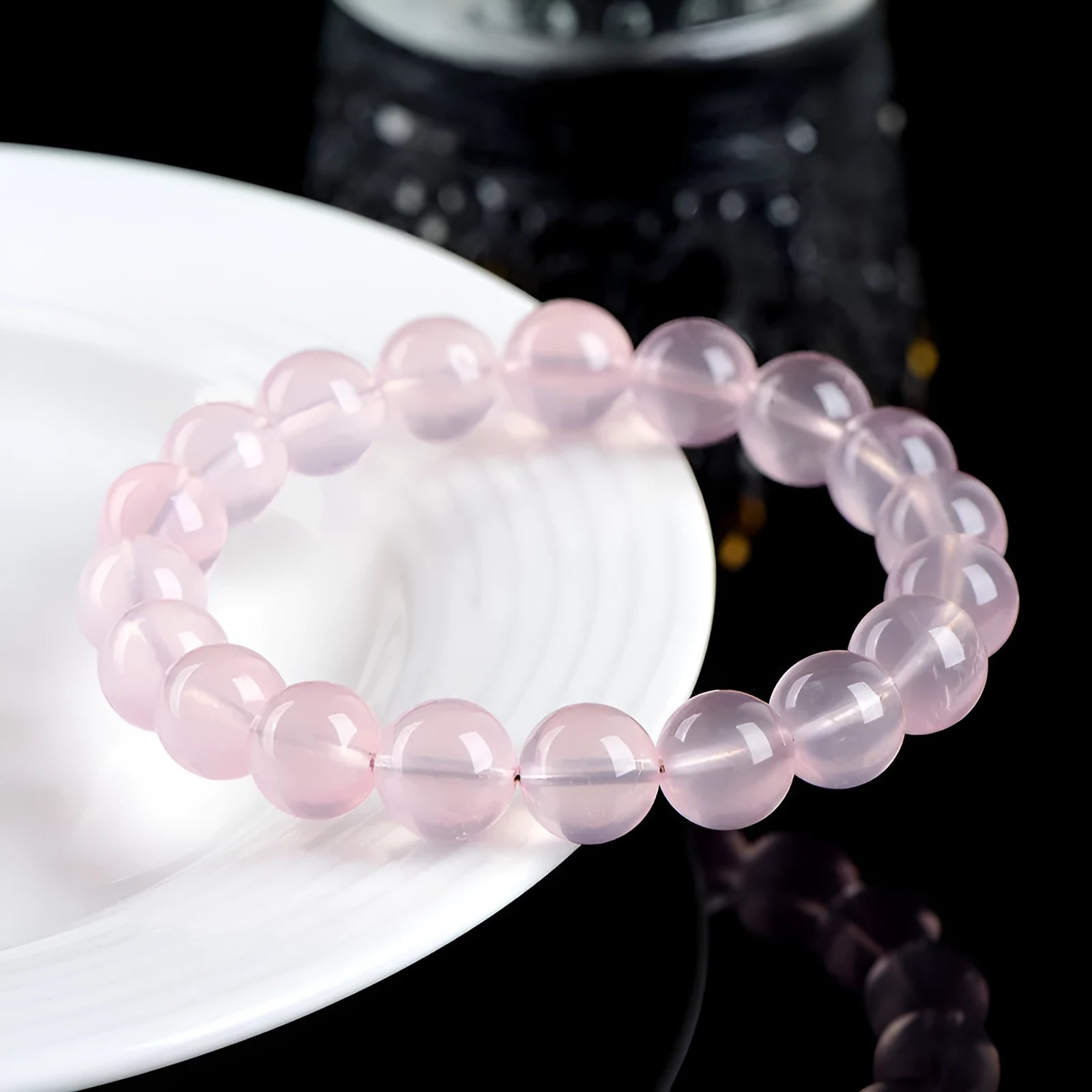 Natural starlight crystal round beads women's bracelet in pink on a wrist, showing polished single circle beads.