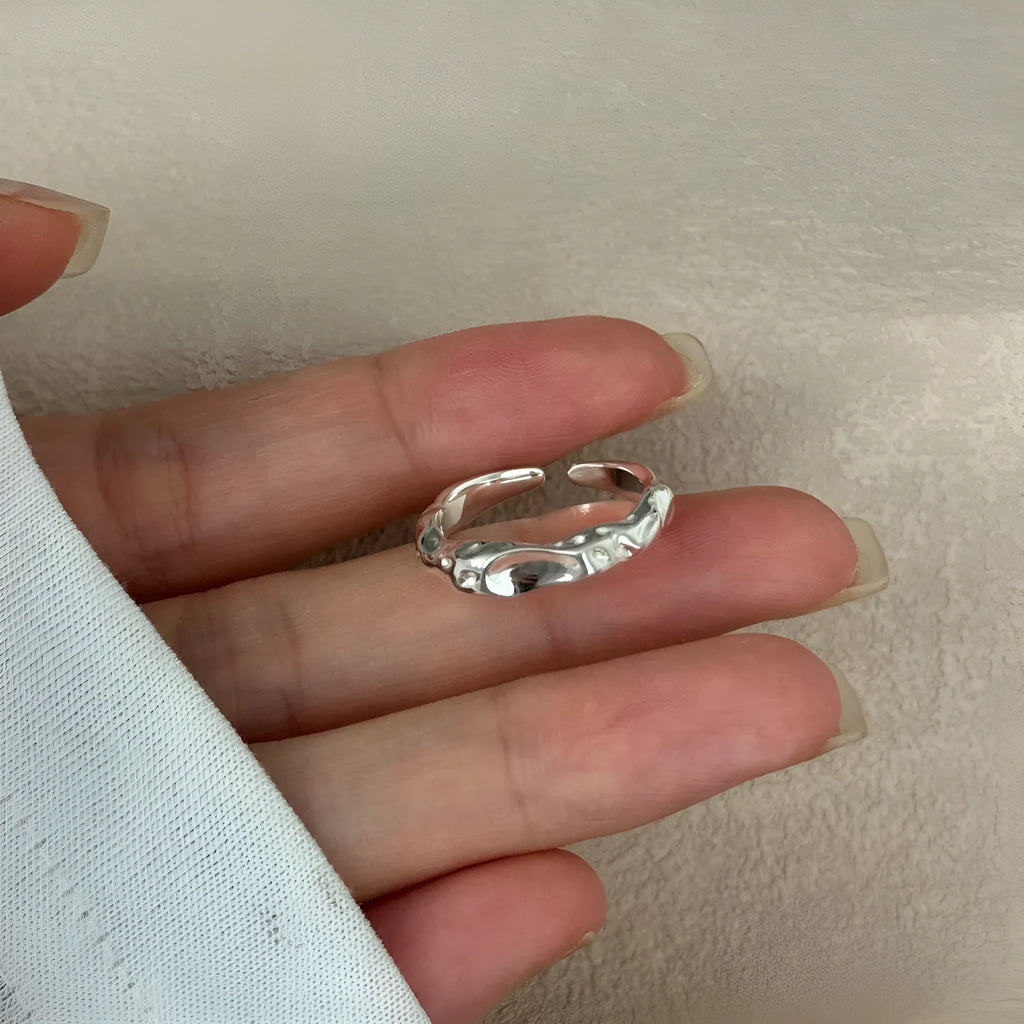 Irregular silver opening adjustable ring for women with electroplated finish on plain background