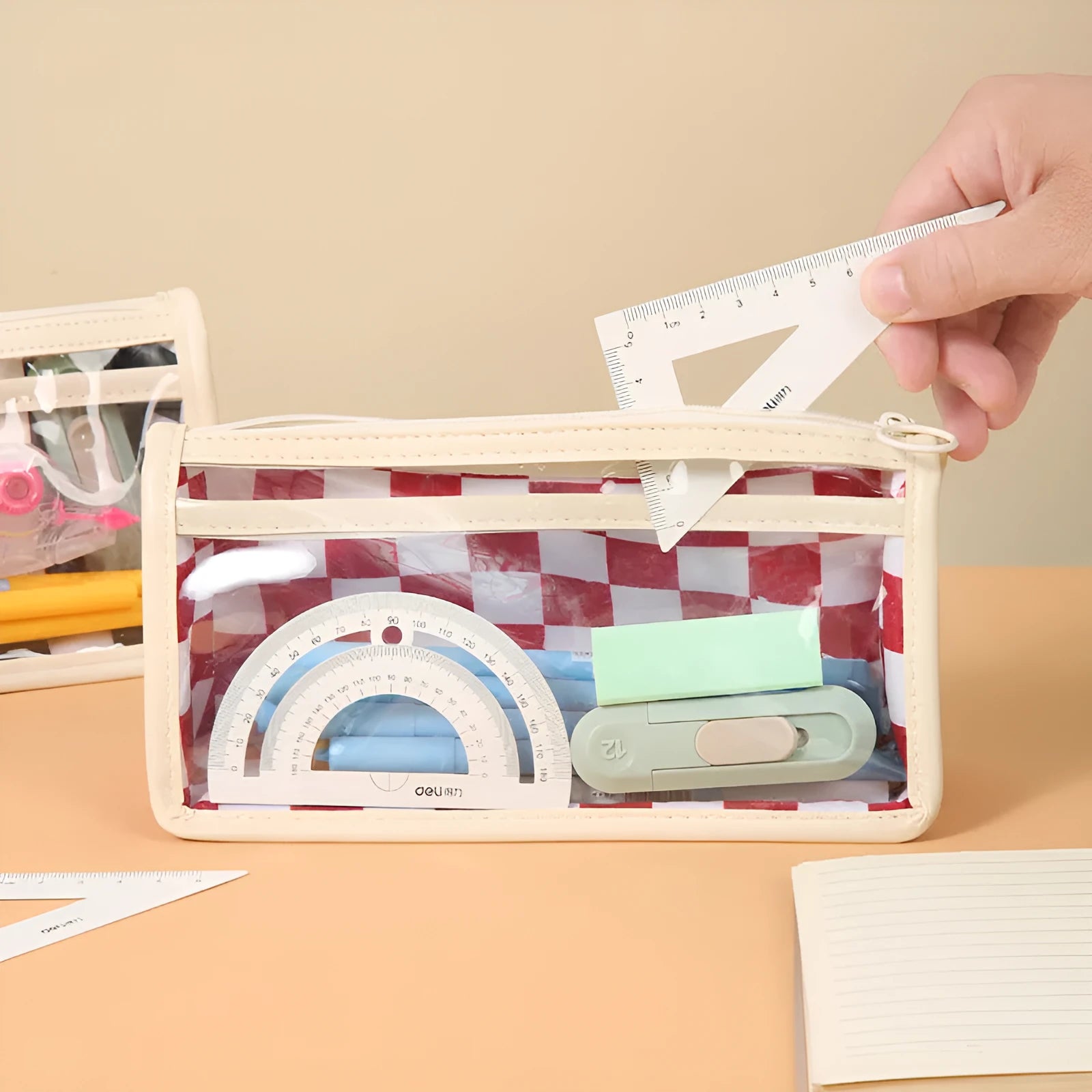 Transparent PVC pencil case with a chessboard grid pattern, showing pens inside.
