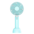 Blue handheld USB mini electric fan with three-speed control on a desk.