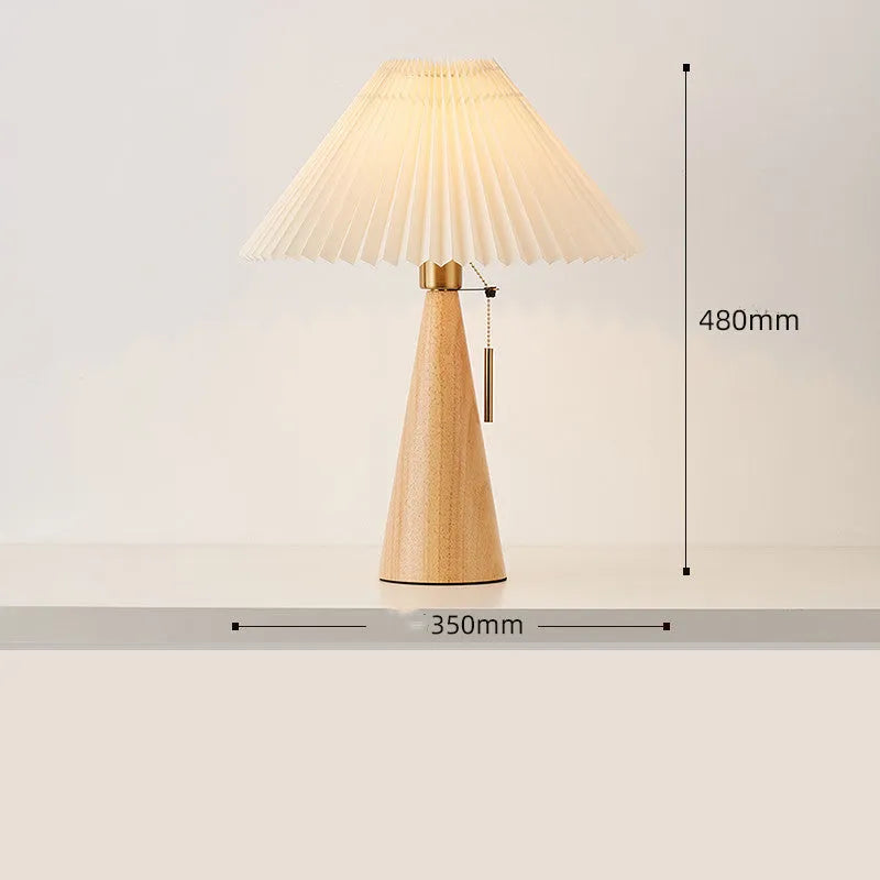 Handmade walnut wood small table lamp with beige pleated cloth shade and LED light on a desk