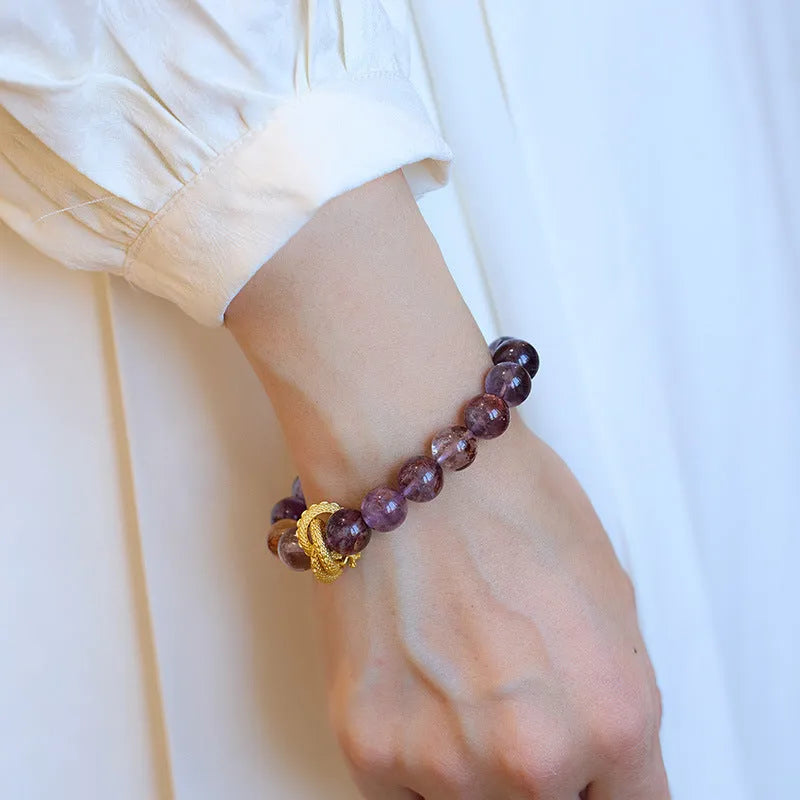 Purple cornucopia crystal bracelet with nine purple lucky charms on wrist