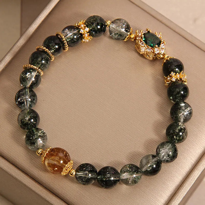 Women's gold rutilated quartz crystal bracelet with green phantom quartz accents, pearls, and rhinestones.