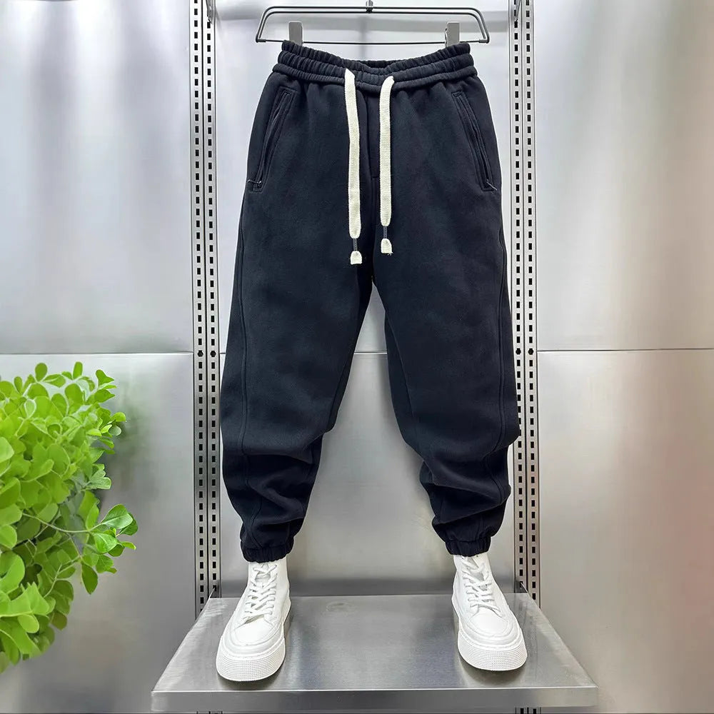 Summer men's solid colour polyester track sweatpants with zippered pockets and ankle ties, black, side view