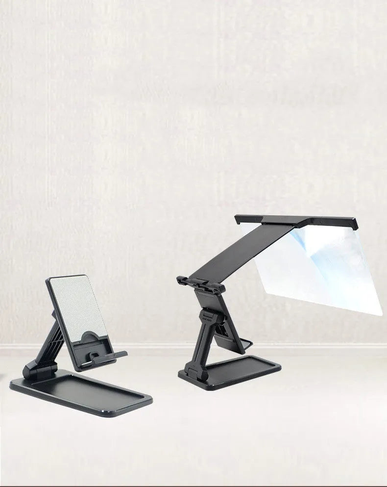 Black foldable mobile phone screen amplifier with a detachable phone holder on a desktop.