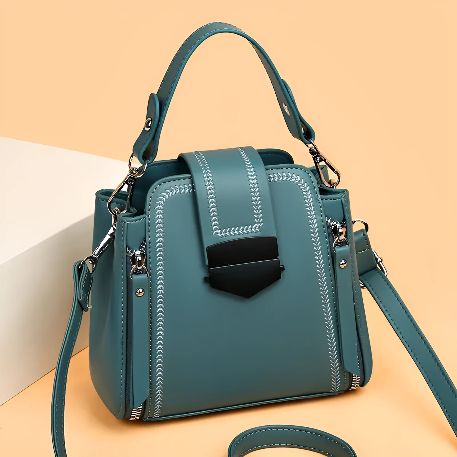 Soft textured PU leather ladies handbag in a square vertical shape with sewn thread detailing.