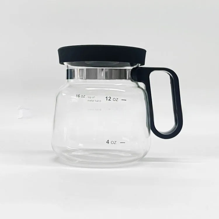 Transparent borosilicate glass stovetop coffee maker with black silicone cover on a hob.