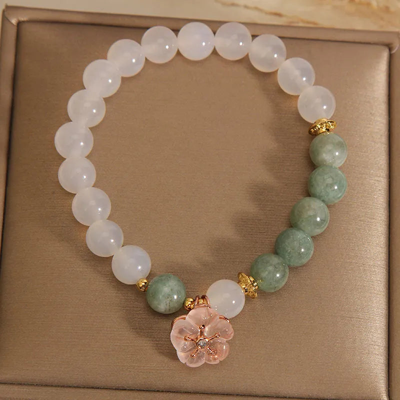 Emerald agate bracelet with white jade flower beads and pink accents on wrist