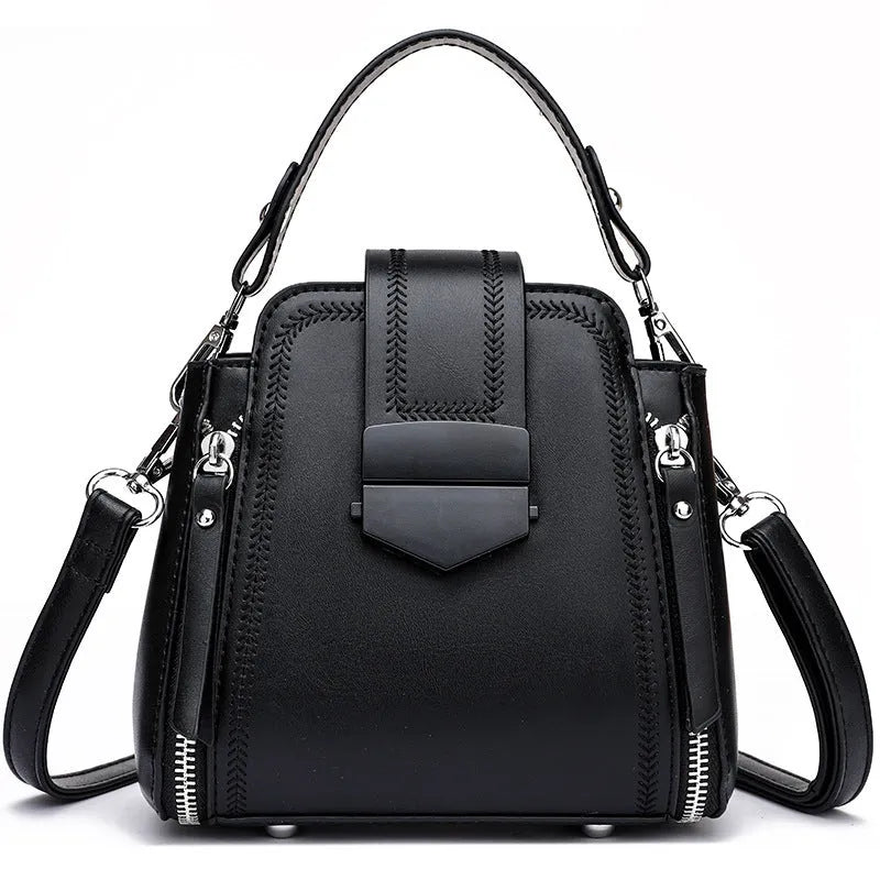Soft textured PU leather ladies handbag in a square vertical shape with sewn thread detailing.