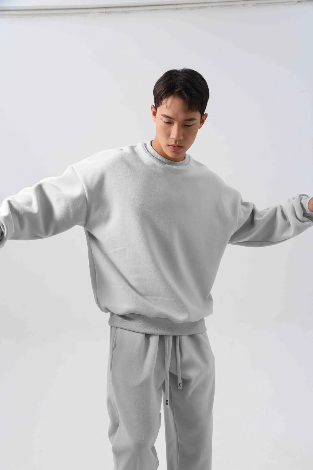 Men's black loose fit polar fleece winter sports suit with long sleeve coat and trousers on a hanger.