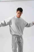 Men's black loose fit polar fleece winter sports suit with long sleeve coat and trousers on a hanger.