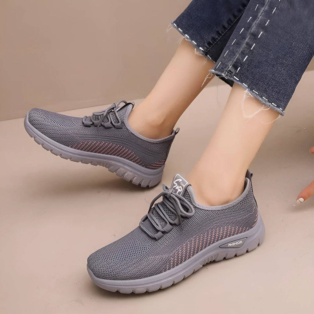 Women's black mesh sneakers with round toe, cross-strap details, and lace-up front on rubber sole