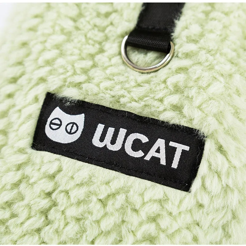 Two-legged sleeveless fleece dog vest with integrated leash ring in soft green or neutral beige, sizes XS to XL