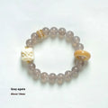 Hand-woven bracelet with 10mm round grey agate and mellite beads on a wrist.