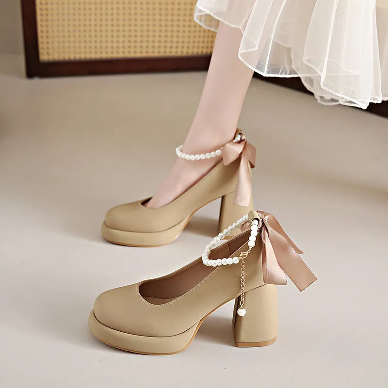 Beige women's Mary Jane shoes with chunky heel, ankle strap, pearl detail, and round toe.
