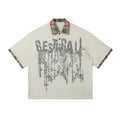 Men's loose blue short-sleeved top with asymmetric cut and graffiti print on the lapel.
