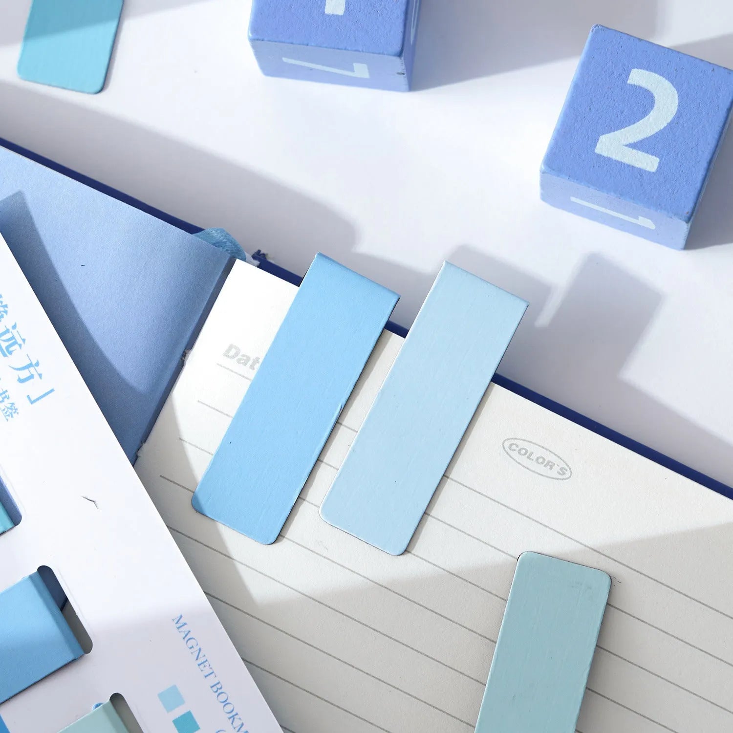 Set of four magnetic morandi colour block bookmarks in soft pastel hues on a page
