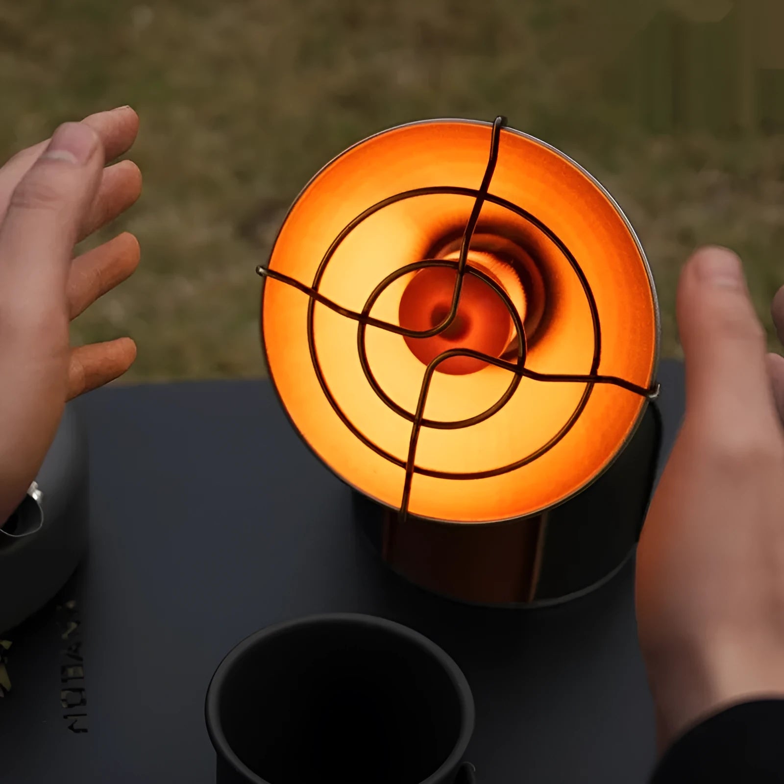 Black and orange portable outdoor camping heater with automatic ignition on a stainless steel and plastic body.