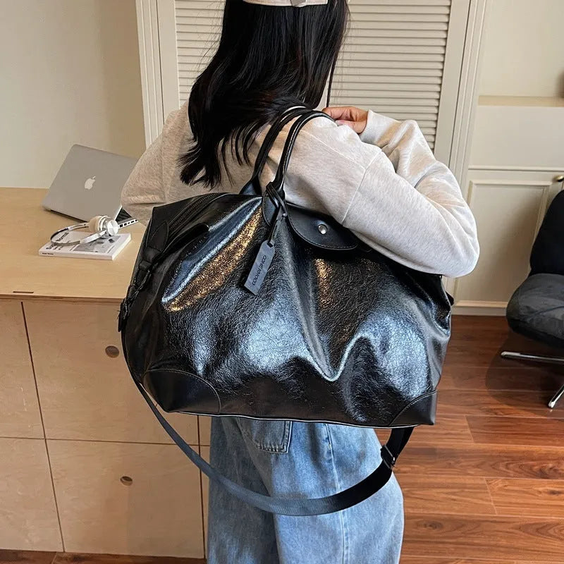 Women's large capacity hand-carry travel bag in black or silver with 36-55 litre capacity