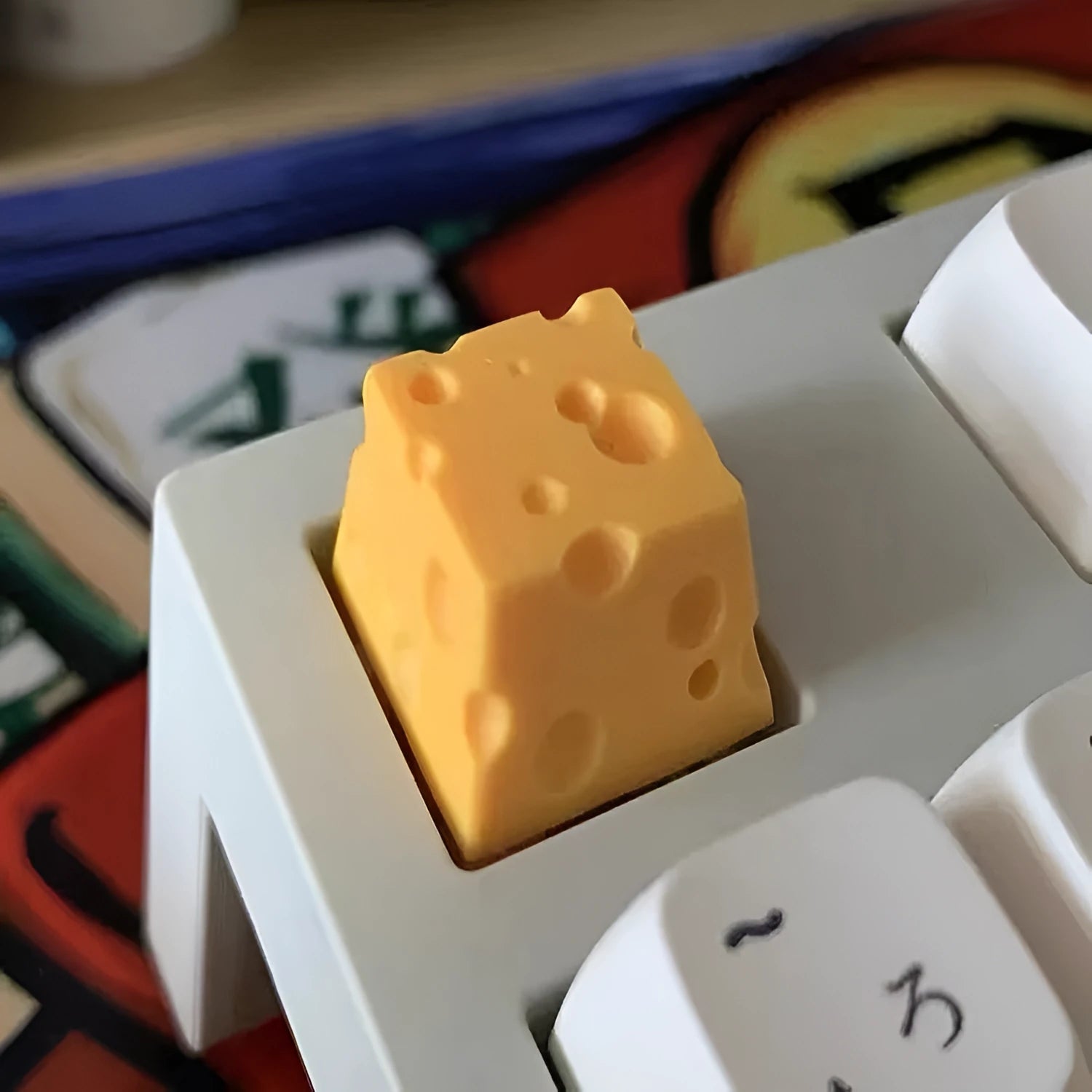Close-up of a bright yellow resin key cap with a detailed sculpted cheese design.