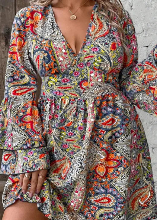 Plus size woman in a printed V-neck dress with long bell sleeves and an A-line skirt.