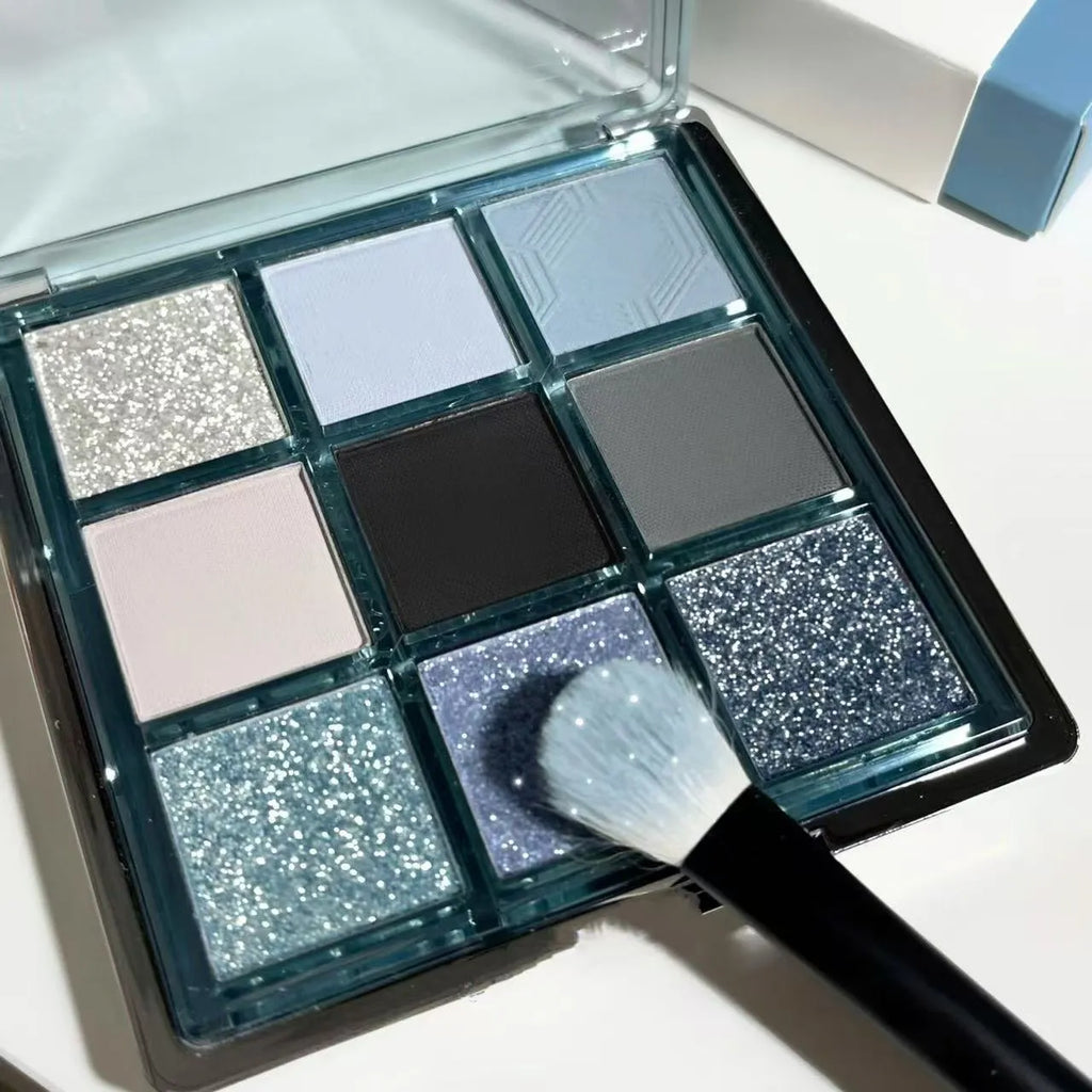 MUGELEEN nine-colour eye shadow palette open showing blue smoked and earth tone shades with matte and shimmer finishes.