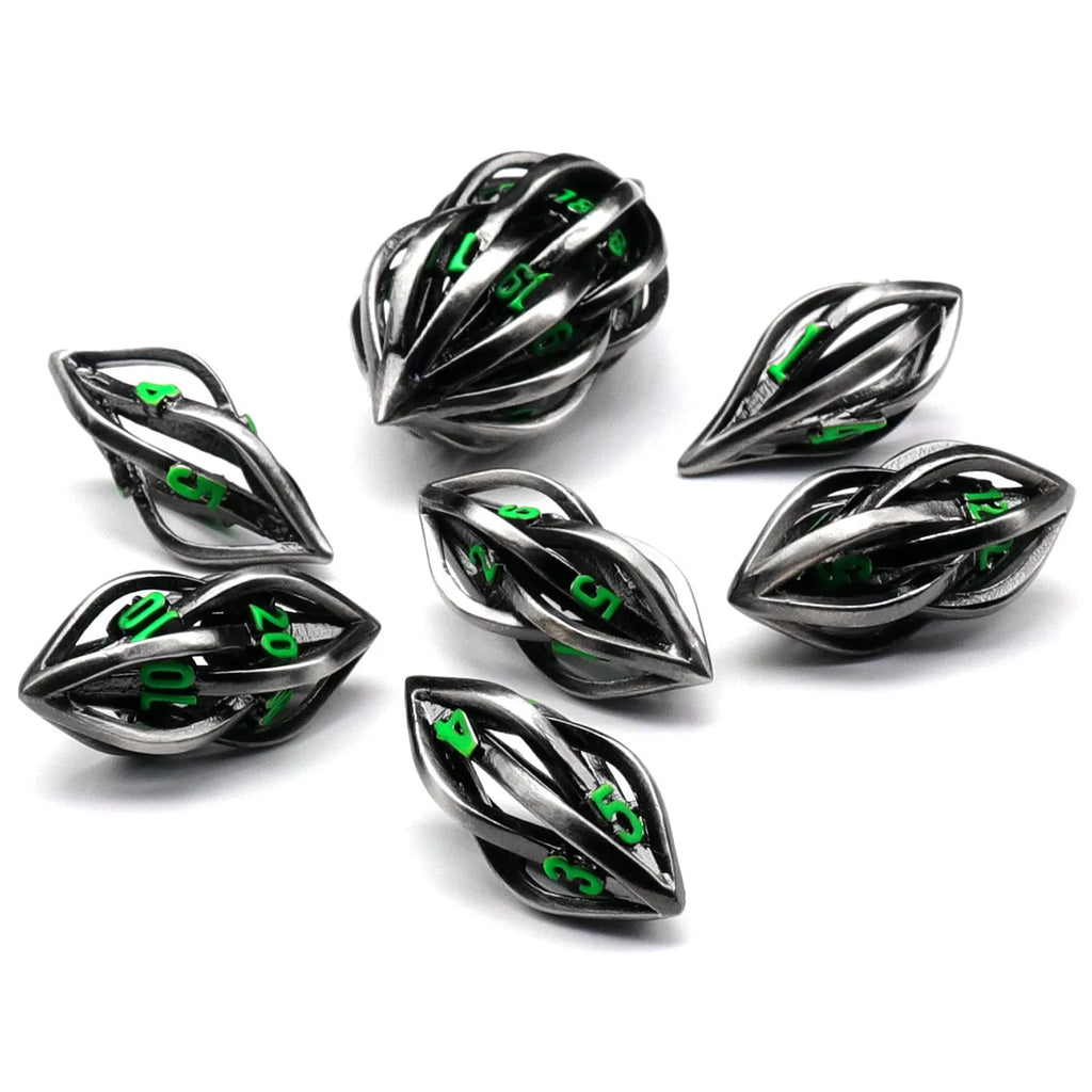 Seven metal melon seed shape dice in antique silver with coloured characters on a surface