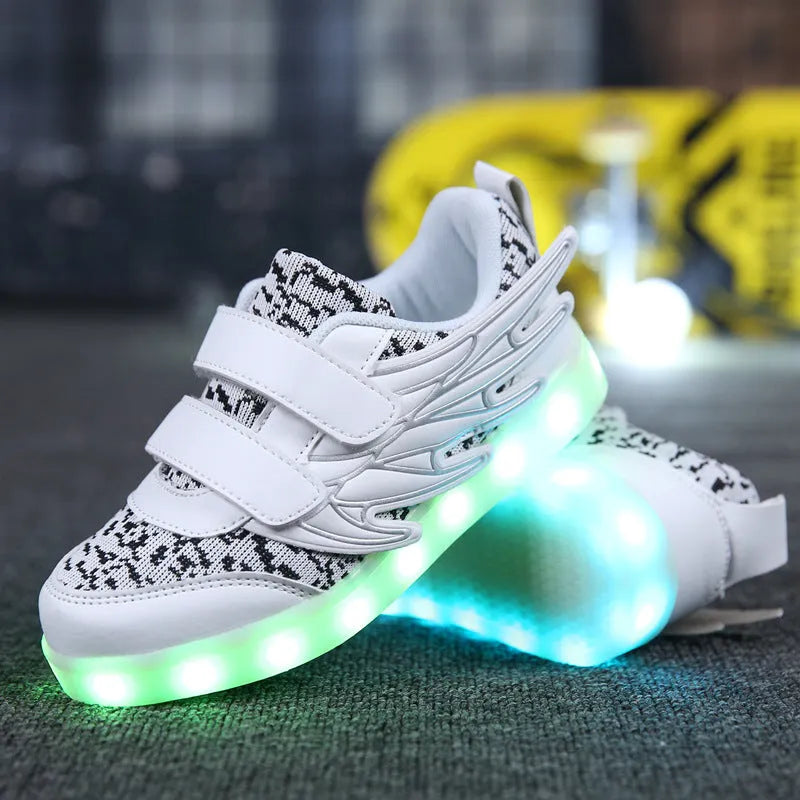 Children's plum red and white LED light-up sneakers with colourful winged lights, showing USB charging port.