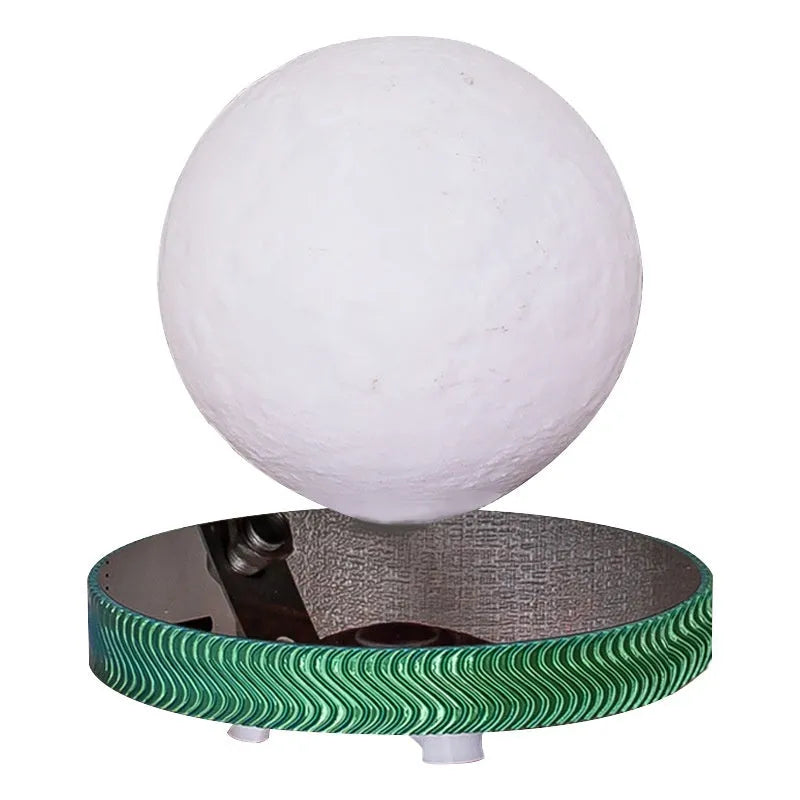 Small magnetic levitating moon night lamp with 3D-printed details on a table.