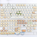 Steamed bread character march past design on a set of white PBT 7u keyboard key caps.