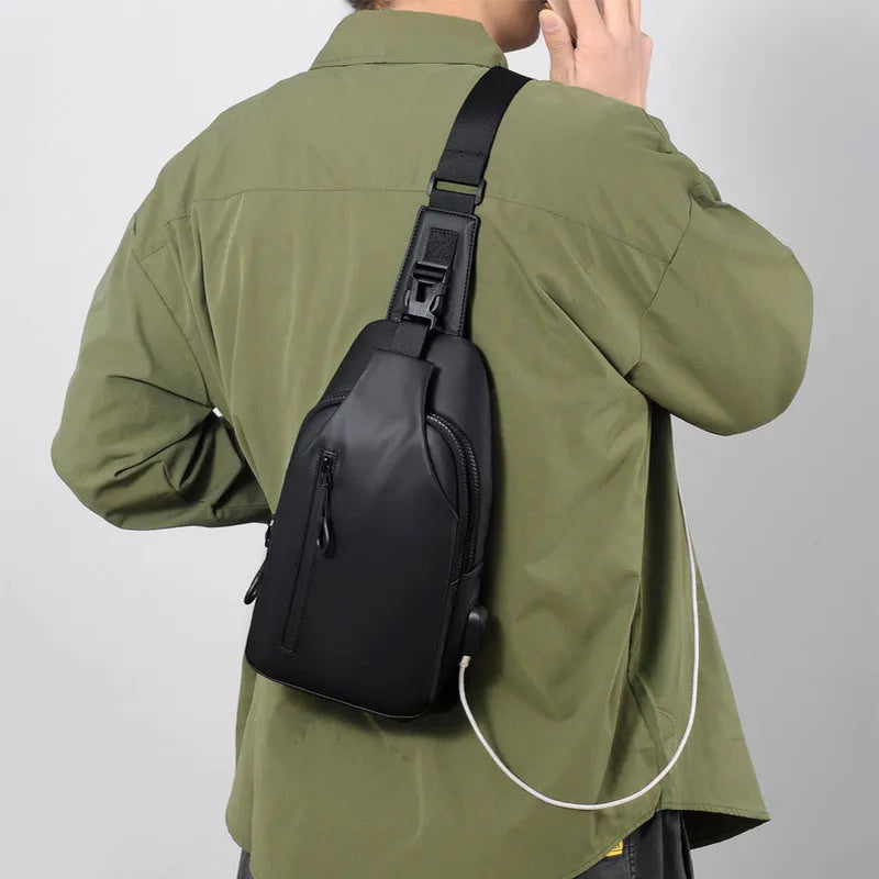 Black sling crossbody chest bag for men with zipper closure and stitched detail on a white background